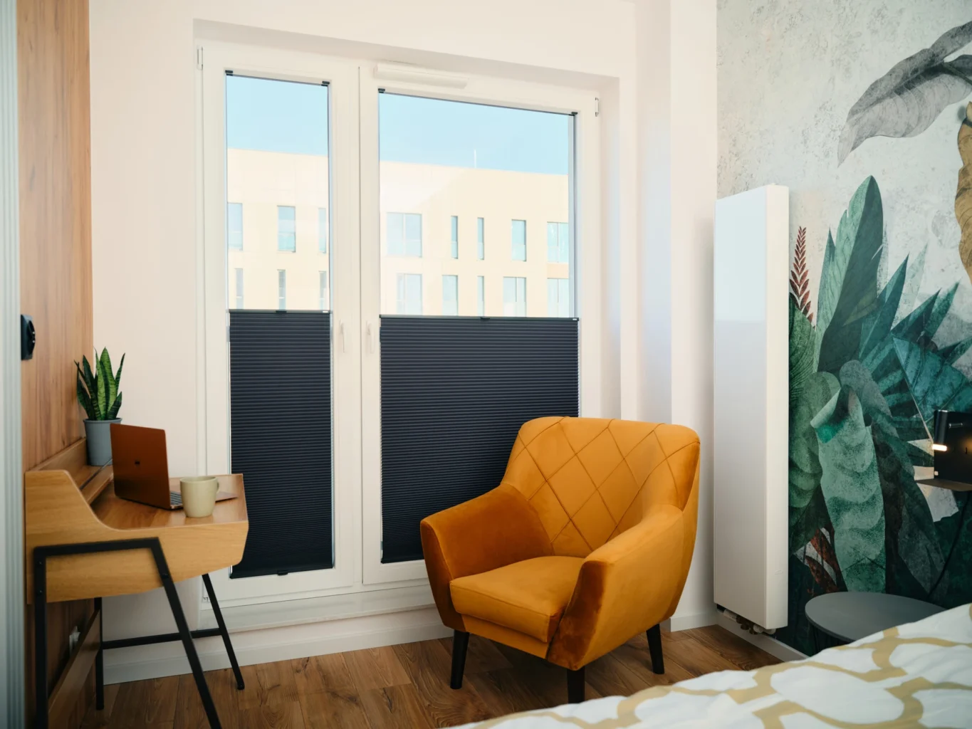 Modernes Wohnzimmer mit gelbem Sessel und Holztisch vor großen Fenstern