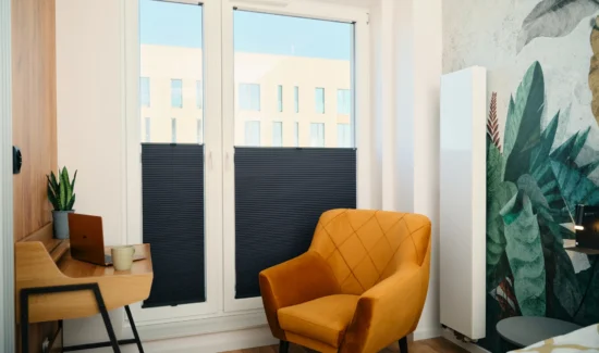 Modernes Wohnzimmer mit gelbem Sessel und Holztisch vor großen Fenstern