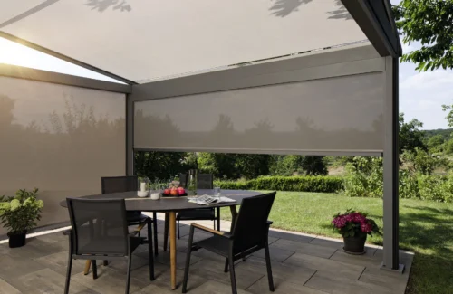 Moderne überdachte Terrasse mit Sonnenschutz und Gartenmöbeln