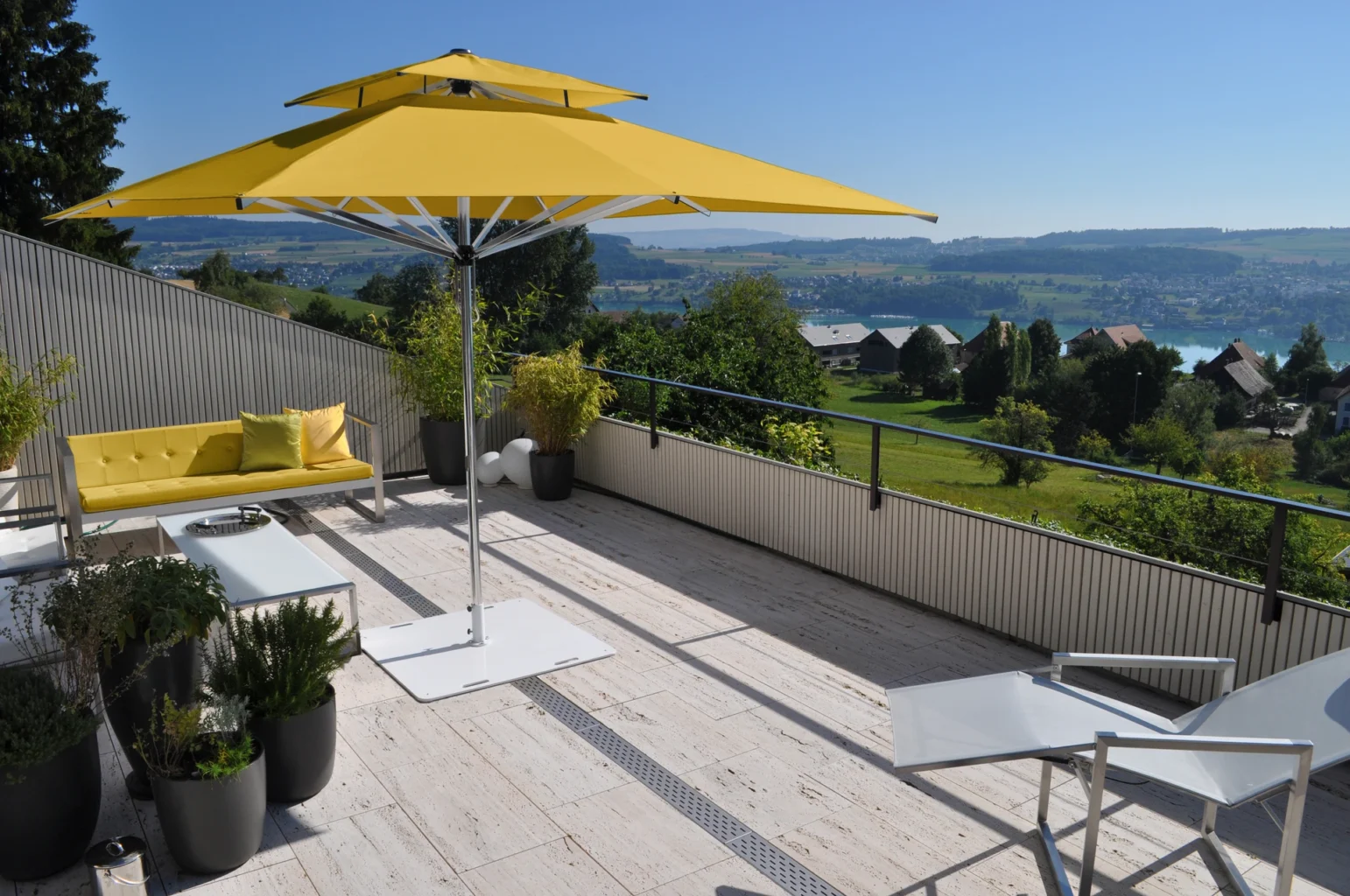 Moderne Terrasse mit gelbem Sonnenschirm und Panoramablick
