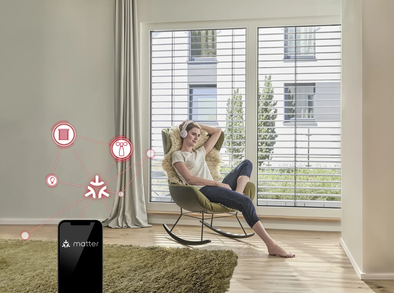 Frau entspannt im Wohnraum mit großen Fenstern und Raffstores, gesteuert über Smart Home System mit Matter-Technologie