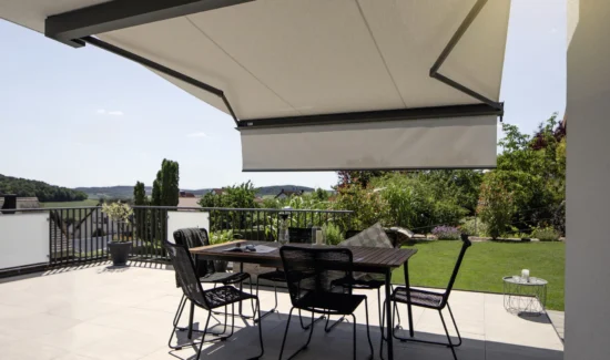 Moderne Terrasse mit Markise und Gartenmöbeln