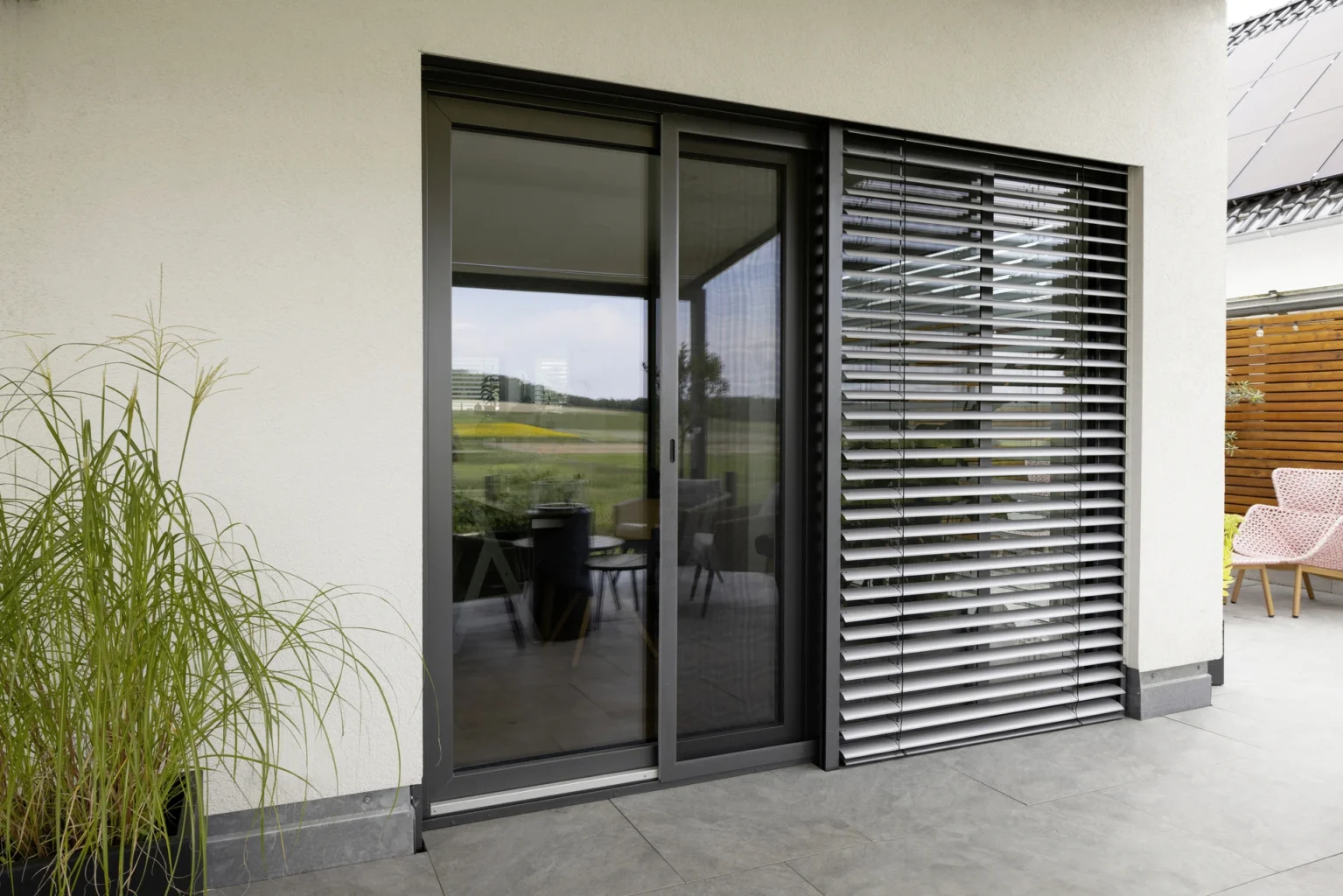 Moderne Terrassenverglasung mit Sonnenschutz und stilvoller Einrichtung