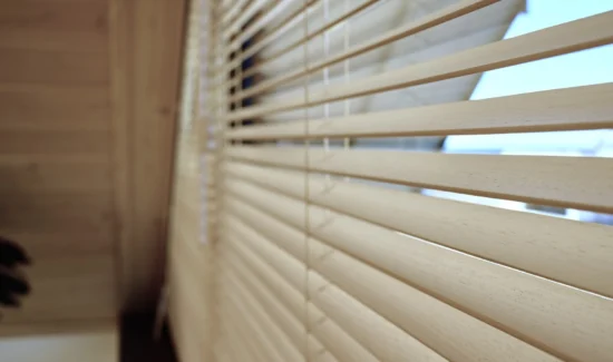 Nahaufnahme von modernen Holzjalousien am Fenster
