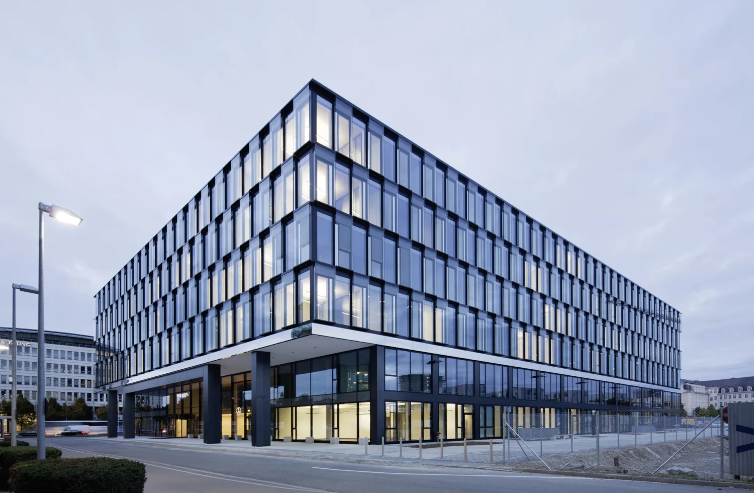 Modernes Bürogebäude mit Glasfassade bei Dämmerung