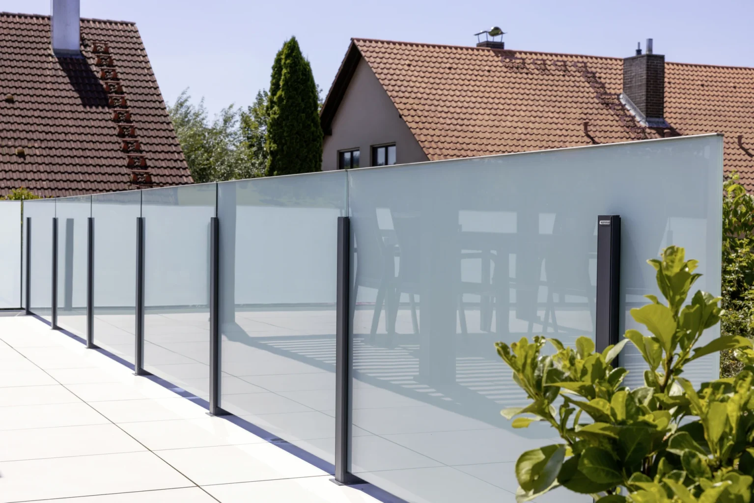 Moderne Glasabtrennung auf einer Terrasse mit Sichtschutz und Pflanzen