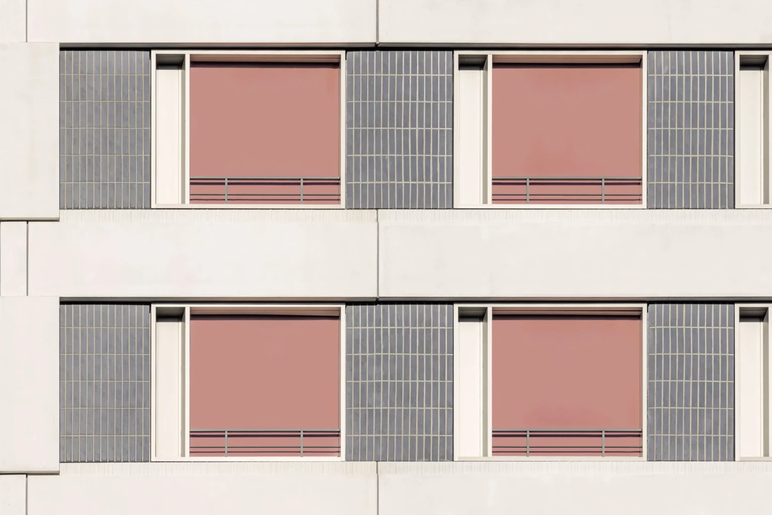 Moderne Fassade mit rosa Fensterläden und geometrischen Mustern