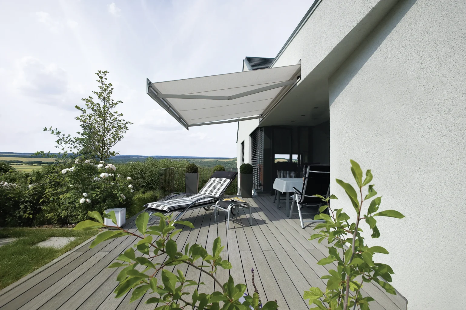 Moderne Terrasse mit Sonnenschutz und Liegestühlen