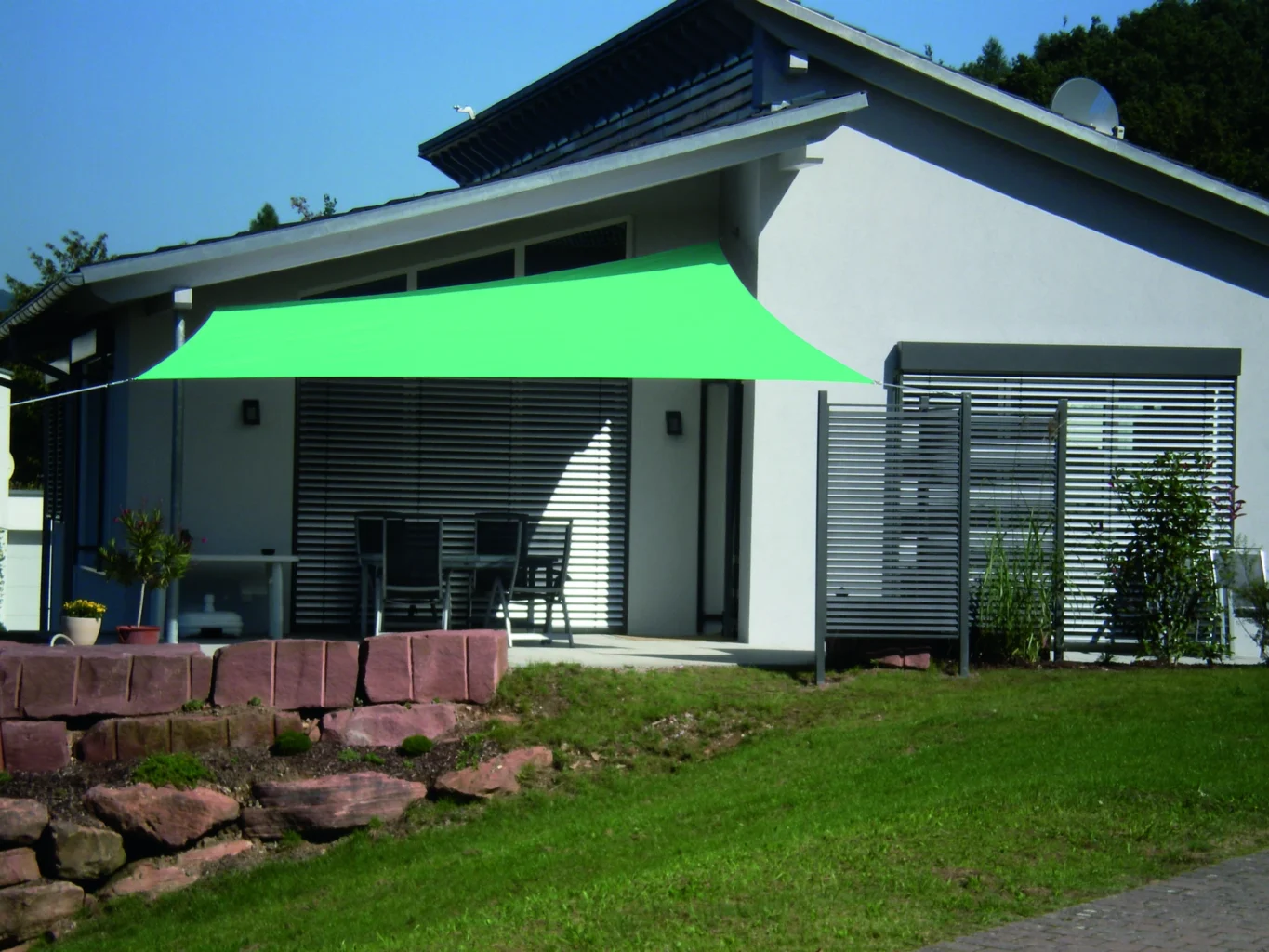 Moderne Terrasse mit grünem Sonnensegel
